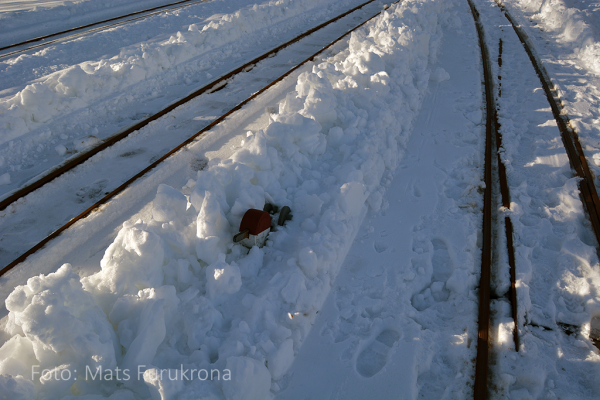 Ett växelklot inklämt i snövallen mellan spåren